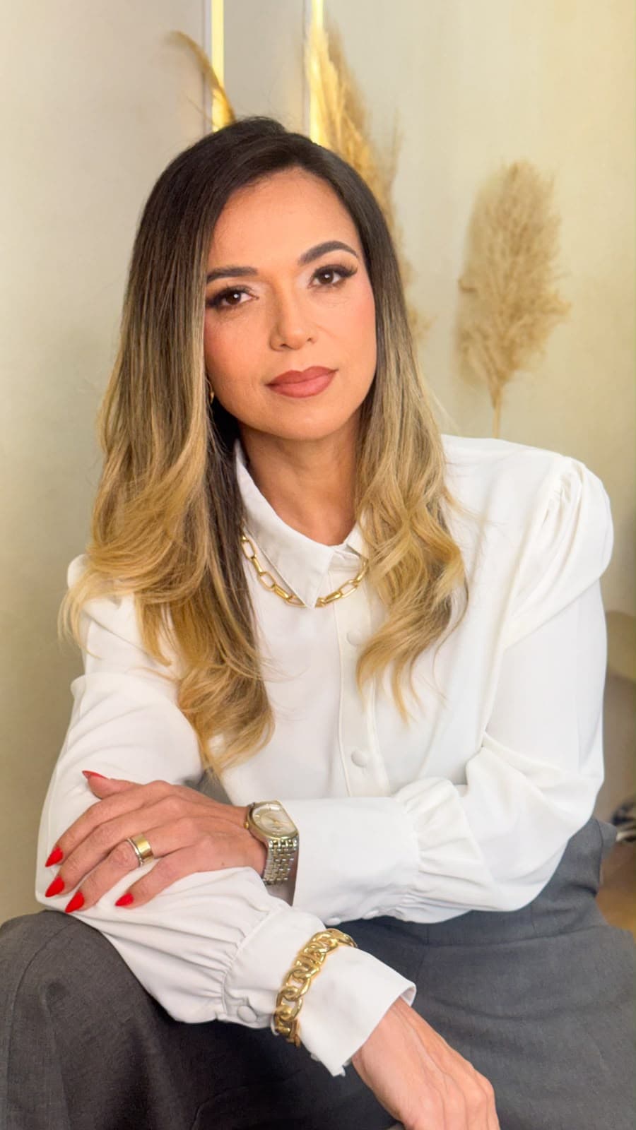 Retrato profissional de Queila Santiago sentada em seu consultório