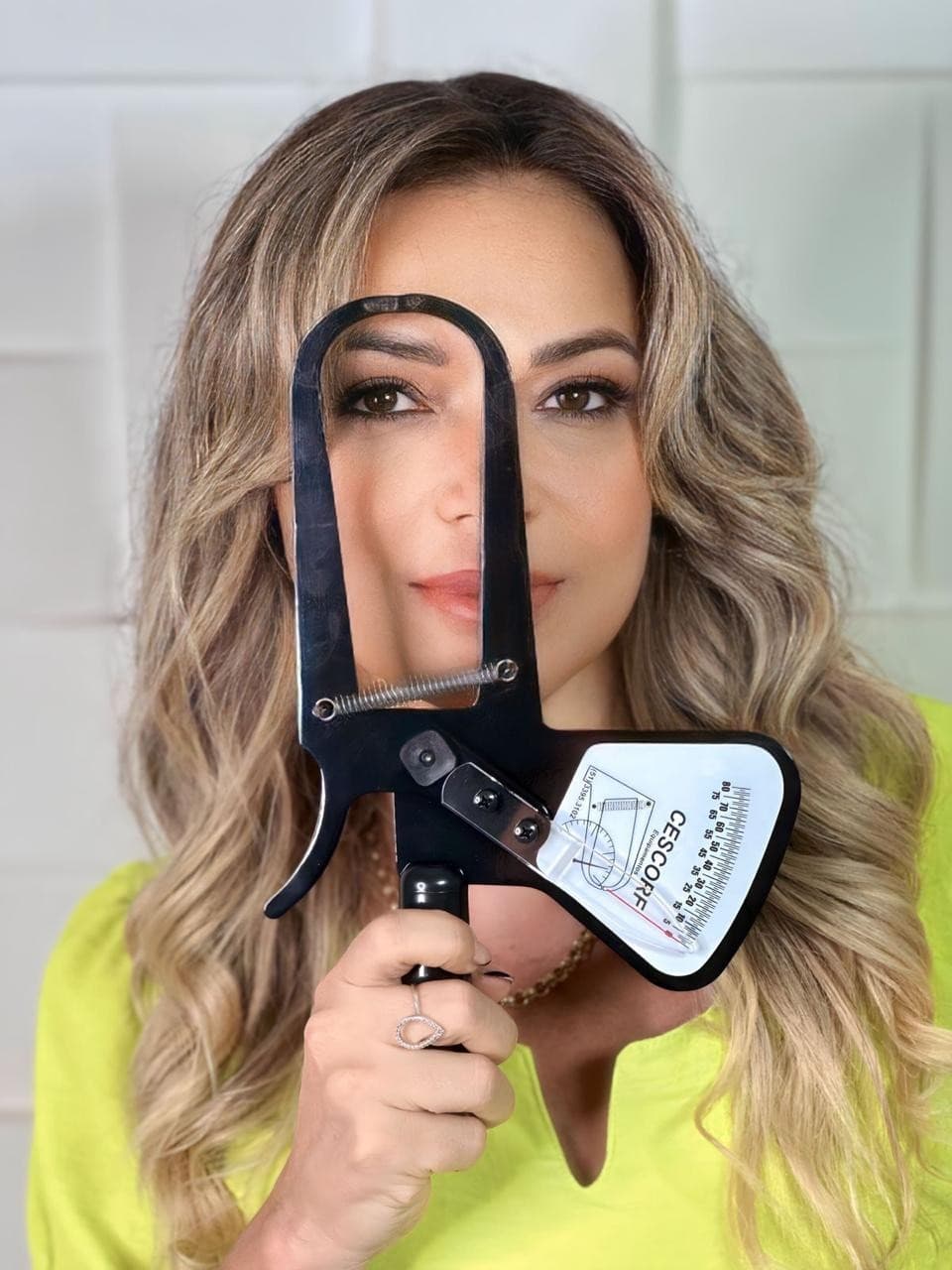 Profissional com instrumento de avaliação corporal